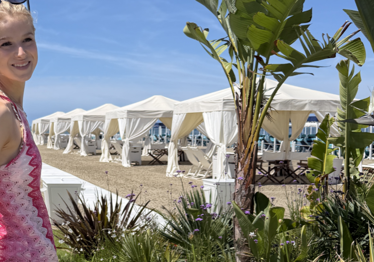 Sonnenschutz nach Botox, nach Filler Sonne, nach Peeling Sonne, Sonnenschutz ästhetische Behandlung, UV-Schutz nach Microneedling. Bild von einer jungen Frau in pinkem Kleid am Strand mit Palmen und Strandzelten