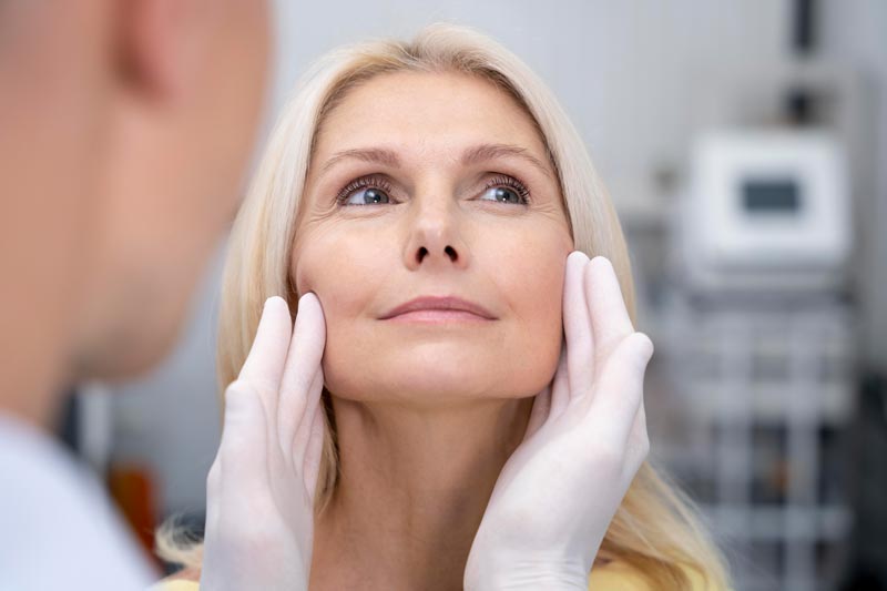close-up-doctor-checking-smiley-woman-mod Polynukleotide – Biologische Hautregeneration auf Zellebene, lächelnde Frau mit Arzt