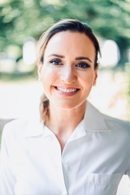 image5 Dr. Sarah Ophoff, Fachärztin für Dermatologie und aesthetische Dermatologie. Dr. Ophoff in weißer Bluse vor einem frühlingshaften Hintergrund im Garten. Sie lächelt freundlich in die Kamera